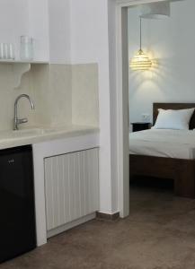 a kitchen with a sink and a bed in a room at Belvedere Studios in Astypalaia Town