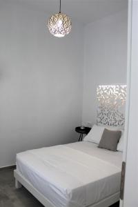 a bedroom with a white bed with a pendant light at Belvedere Studios in Astypalaia Town