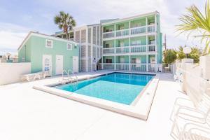 a villa with a swimming pool in front of a building at Emerald Shores #1001 Condo in Panama City Beach