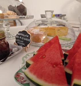 a plate of watermelon on a table with a cake at B&B S. Trinità 18 Suites & Rooms in Trento