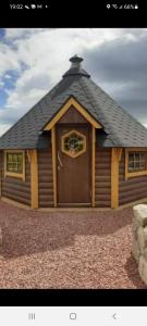 a large wooden cabin with a large door at Hesket caravan park Plot Number 7 STRICTLY NOT FOR COMMERCIAL USE in High Hesket