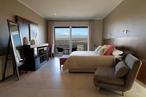 1 dormitorio con 1 cama, 1 silla y 1 ventana en Gaia Lodge en Tupungato