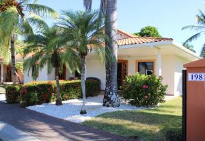 a house with palm trees in front of it at Villa Serenidad in Paquera