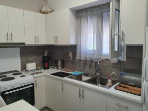 a kitchen with white cabinets and a sink at Daglas Beach House in Nydri