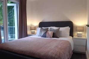 een slaapkamer met een groot bed met kussens en een raam bij Chalet 174 Glan Gwna Park Caernarfon in Caeathro