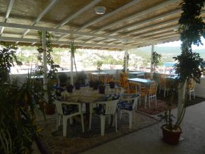 a patio with a table and chairs and plants at Akkin Pansiyon in Kaş