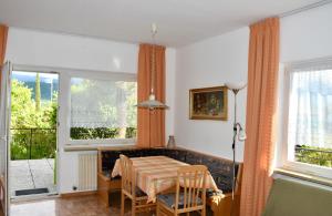een eetkamer met een tafel en twee ramen bij Haus Klavenz in Caldaro