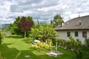 een tuin van een huis met bomen en een gebouw bij Haus Klavenz in Caldaro