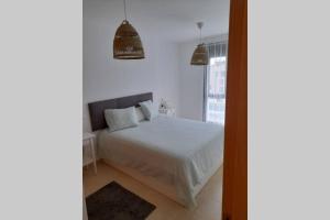 a bedroom with a white bed and a window at Apartamento Sarastur in Posada de Llanes +13 photos