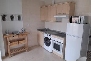 cocina con nevera blanca y lavadora en Apartamento Aurora llanes 4 pax, en Posada de Llanes