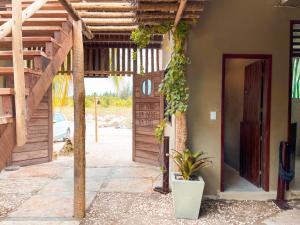 uma porta aberta para uma casa com uma planta em Pousada Sand Farm em Prea