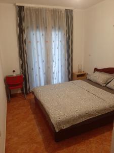 a bedroom with a bed and a window with curtains at Apartments Nurkovic in Dobra Voda
