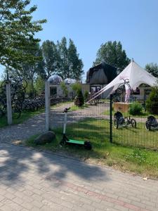 a fence with a white tent and a scooter at Złoty Piach in Władysławowo