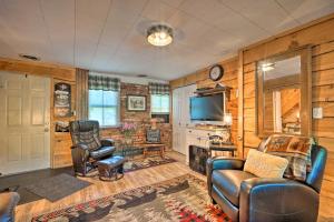 a living room with wooden walls and a tv and chairs at Adirondack Mountains Cottage Near Gore Mountain! in Warrensburg