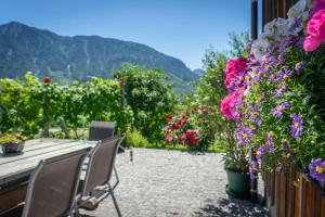 un patio con flores, mesa y sillas en Lovely house with mountain view & big garden in Bad Aussee, en Bad Aussee
