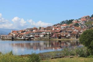 een stad op een heuvel naast een waterlichaam bij Chalet Meu Lar in O Casal Pontevedra