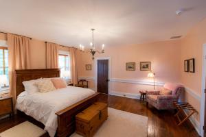 1 dormitorio con 1 cama y 1 silla en Thomas Rose Inn, en Lewisburg