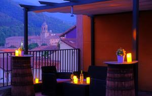 balcón con mesas y velas y vistas a la ciudad en Casa Rural La Campana Con o sin Ático, en San Millán de la Cogolla