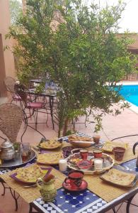 une table avec des assiettes de nourriture au-dessus dans l'établissement Riad Dar Bergui, à Ouarzazate