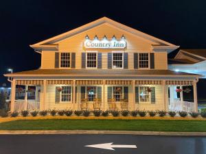 Una casa amarilla con un cartel de posada rural. en Country Inn of Hazlet en Hazlet