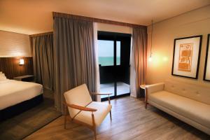 a hotel room with a bed and a chair and a window at Holiday Inn Fortaleza, an IHG Hotel in Fortaleza