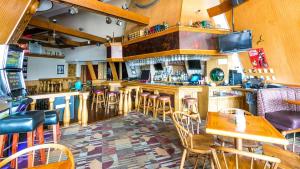 un bar con tavoli e sedie in legno in un ristorante di Wrangler Inn Mobridge a Mobridge