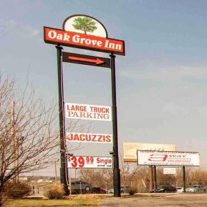 a sign for a oat grove inn with signs at Oak Grove Inn in Oak Grove