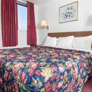 Habitación de hotel con cama con colcha colorida en Oak Grove Inn, en Oak Grove
