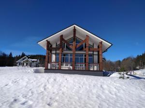 a log cabin in the snow with snow at Cottage Village Moklakhti in Kortela