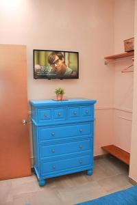 a blue dresser with a tv on a wall at Apartment Casa Turquesa in La Paz