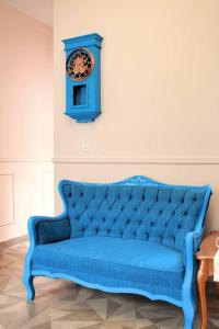 a blue couch with a clock on a wall at Apartment Casa Turquesa in La Paz