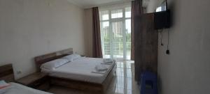 a bedroom with two beds and a large window at Guest House Marineza in Gonio