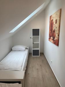 a small bedroom with a bed and a painting on the wall at FreiRaum in Annweiler am Trifels