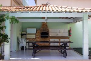 a patio with a table and a brick fireplace at Casa das Dunas in Cabo Frio