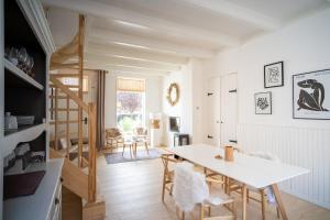 a kitchen and dining room with a table and chairs at Vakantiehuis New Zeeland in Scherpenisse