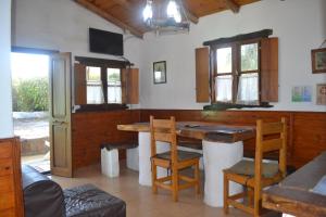 een keuken met een tafel en stoelen in een kamer bij Cabañas Los Relinchos in Capilla del Monte