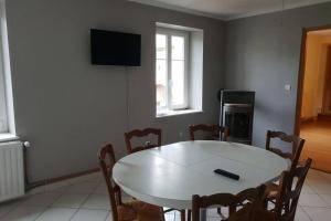 a dining room with a white table and chairs at Appartement in Saint-Bresson