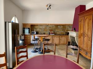 cocina con mesa y nevera en Magnifique villa de charme avec piscine, en Casteljaloux