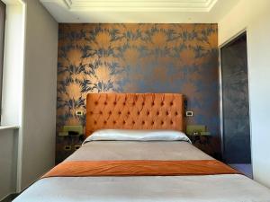sypialnia z łóżkiem z pomarańczowym zagłówkiem w obiekcie Ninfa hotel w mieście Qualiano