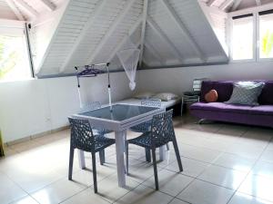 einen Tisch und Stühle im Wohnzimmer mit Sofa in der Unterkunft STUDIO 2- Laurier - 4 pers - proche centre in Terre-de-Haut