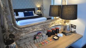 una camera da letto con un letto e uno specchio su un tavolo di Sunnyside Guest House Southport a Southport