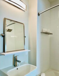 a bathroom with a sink, mirror and bathtub at Art House Hotel in Santa Rosa