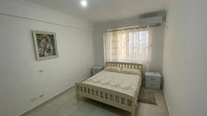 Habitación pequeña con cama y ventana en Adriatik Apartment, en Durrës