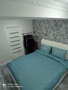 Vip apartment for lovers in Chisinau في كيشيناو: غرفة نوم مع سرير أزرق مع اللوح الأمامي الأبيض