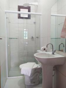 uma casa de banho com um chuveiro, um lavatório e um WC. em Village Funchal 03, Lençóis em Lençóis