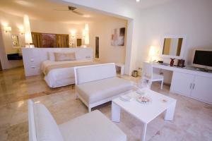 ein großes weißes Schlafzimmer mit einem Bett und einem Tisch in der Unterkunft Grand Sunset Princess - All Inclusive in Playa del Carmen