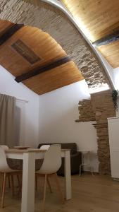 a dining room with a table and a stone wall at Il Centro Storico in Grottole