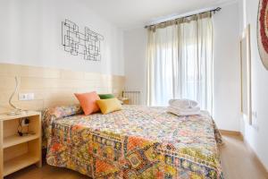 sypialnia z łóżkiem z kolorową narzutą w obiekcie OTAL URBAN de "Casa Otal" w mieście Jaca