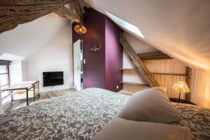 ein Schlafzimmer mit einem großen Bett und lila Wänden in der Unterkunft L'Atypique, charmante maison avec jardin clos in Amboise