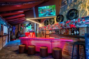um bar com um balcão cor-de-rosa e bancos em Costa Esmeralda Suites em Suances